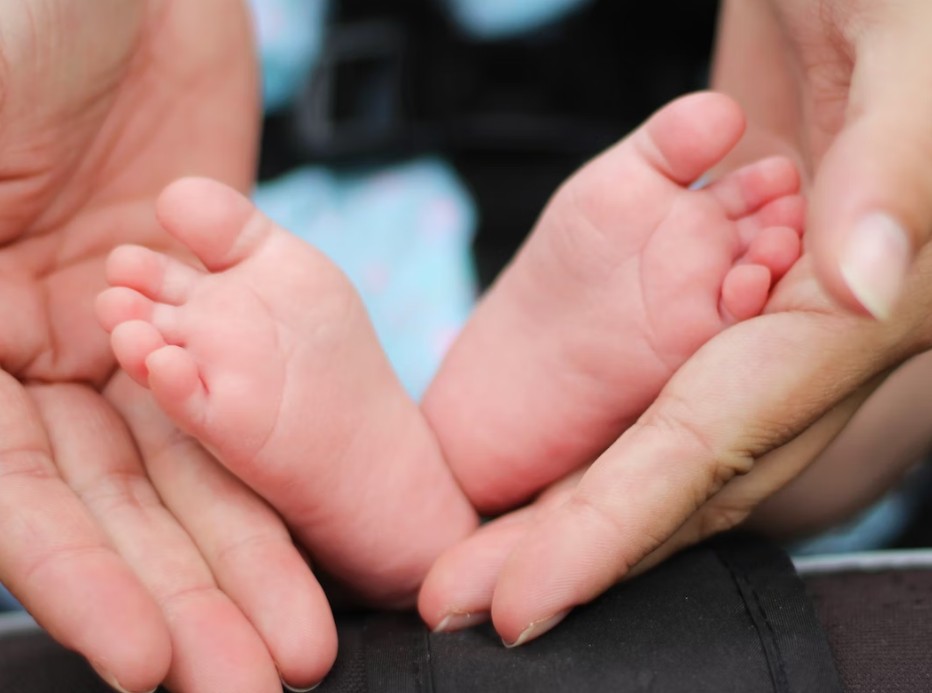 baby foot on mon's hands