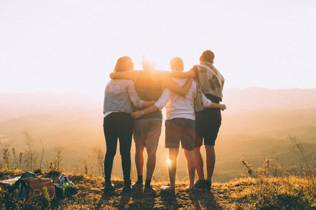 four young people stand on mountain